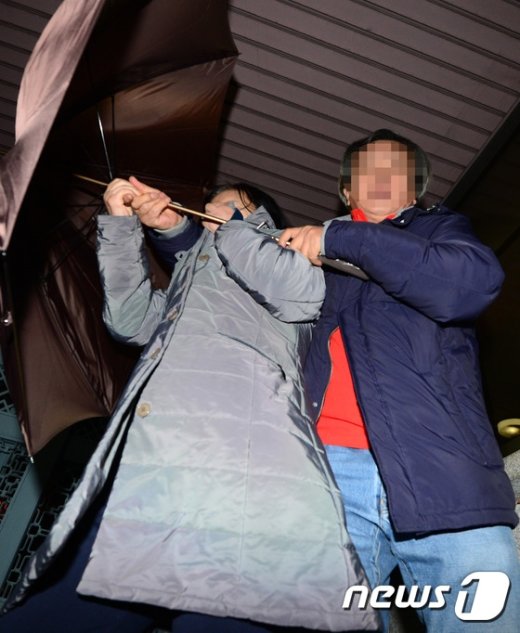 [사진]우산으로 가리며 검찰 빠져나가는 최순득