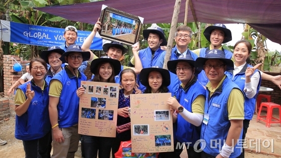 삼성물산 직원들이 지난해 글로벌 사회공헌활동 C&T사업이 펼쳐진 베트남 타이응우옌성 냐미·반닷 마을에서 지역 주민과 함께 기념촬영을 하고 있다/사진제공=삼성물산