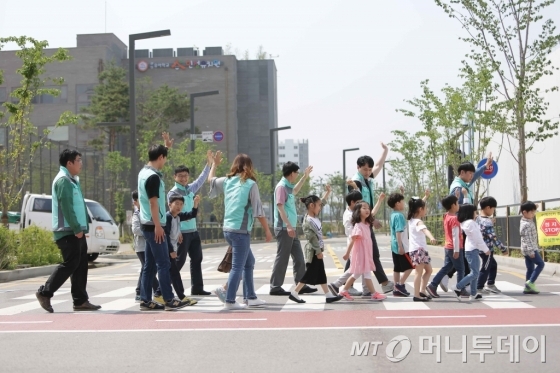 기아차가 지난 25일을 전후해 2주간 진행한 창립기념 봉사주간에서 ‘그린 라이트 카드 캠페인’을 펼쳤다. 기아차 임직원들이 초등학생들에게 등하굣길 안전교육을 진행하고 있다./사진=기아차