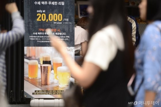 관광객들이 서울 중구 명동에서 '수제 맥주 무제한 리필'이 적힌 입간판 앞을 지나가고 있다. /사진제공=뉴스1