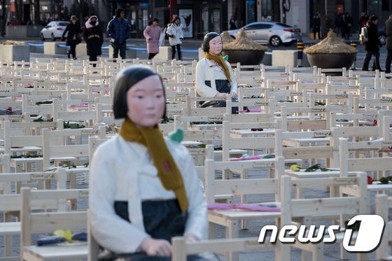 27일 오후 서울 광화문광장에서 일본군 위안부 문제 해결을 위한 2017년 마지막 수요시위 '빈의자에 새긴 약속' 퍼포먼스가 진행되고 있다. 소녀상과 300개의 빈의자 위에 참가자들이 헌화한 꽃이 놓여 있다. 2017.12.27/뉴스1 © News1 유승관 기자