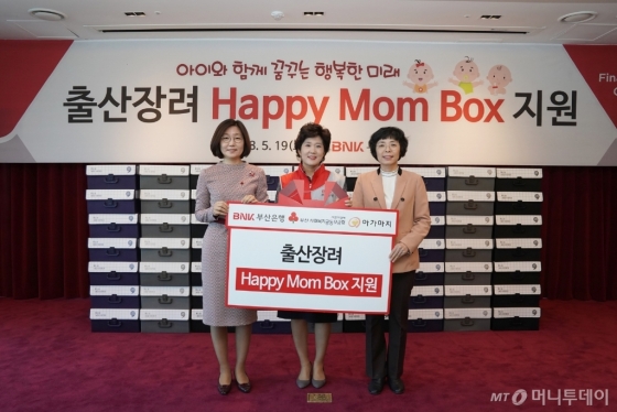 BNK부산은행이 19일 오전 본점에서 희망드림봉사단 100여명과 함께 5000만원 상당의 육아용품 꾸러미 ‘해피맘박스’를 제작해 부산사회복지공동모금회와 부산돌봄사회서비스센터에 전달했다. 사진 왼쪽부터 장보임 부산사회복지공동모금회 사무처장, 권미희 BNK부산은행 부행장, 안혜경 부산돌봄사회서비스센터장./사진제공=BNK부산은행.