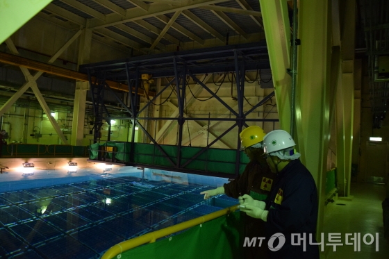 지난달 28일 경북 경주시 양남면 나이리 월성원자력본부 월성 2호기의 사용후핵연료 습식저장시설(수조)의 모습. 200평 남짓의 수조에 총 3만200여다발의 사용후핵연료가 저장돼 있다. 본지 기자(오른쪽)가 직접 방사능관리구역에 들어가 사용후핵연료 저장실태를 확인하고 있다./사진제공=한국수력원자력