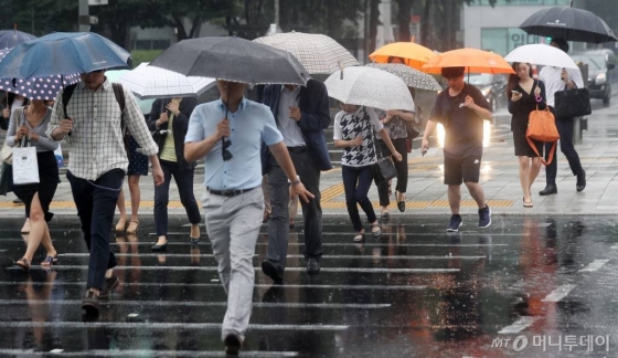 서울 광화문네거리에 시민들이 우산을 쓴 채 발걸음을 옮기고 있다.