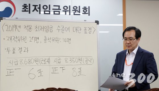  2019년도 최저임금이 8350원으로 확정됐다.   류장수 최저임금위원회 위원장이 14일 정부세종청사 고용노동부 내 최저임금위 전원회의장에서 열린 15차 전원회의를 마친 뒤 최저임금 투표 결과가 적힌 칠판 앞으로 이동하고 있다. 재적인원 27명 중 사용자위원과 민주노총 소속 근로자위원을 재외한 14명이 근로자위원안 8680원과 공익위원안 8350원을 투표한 결과 8표를 얻은 공익위원안 8350원이 최종 확정됐다. 2018.7.14/뉴스1  