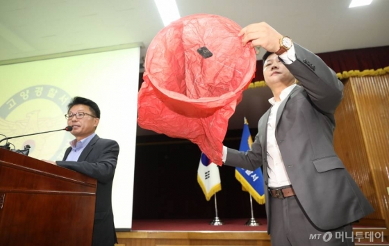 9일 경기 고양경찰서 관계자가 화재 원인으로 지목되는 풍등과 동일한 모형을 공개하고 있다. / 사진=뉴시스