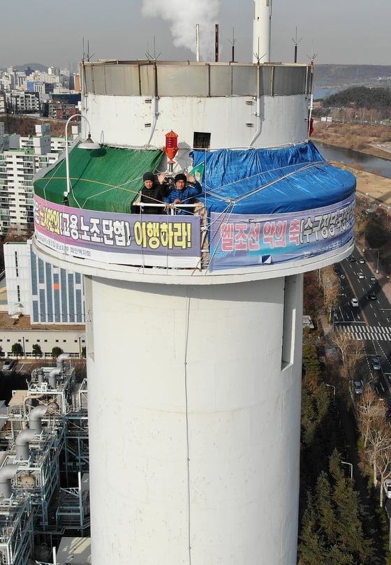 지난달 25일 서울 양천구 목동 열병합발전소 굴뚝에서 고공농성을 벌이고 있는 파인텍노조 홍기탁 전 지회장(왼쪽)과 박준호 사무장이 손을 흔들고 있다. /사진=뉴스1