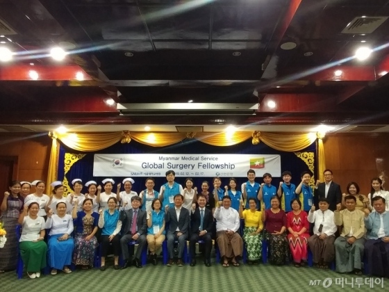 이상화 주미얀마 한국 대사(앞줄 왼쪽에서 여덟번째), 따 툰 쩌(Thar Tun Kyaw) 미얀마 보건복지부 사무차관(앞줄 왼쪽에서 아홉번째), 신한은행 자원봉사단, 서울대학교병원 공공보건의료사업단, 미얀마 양곤 어린이병원 관계자들이 지난 15일 양곤 어린이병원 의료교육캠프 현장에서 함께 파이팅을 외치는 모습./사진제공=신한은행.