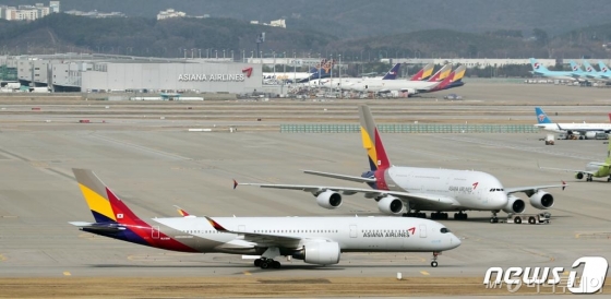(인천공항=뉴스1) 이재명 기자 = 금호아시아나그룹(금호그룹)이 결국 유동성 위기를 해결하기 위해 아시아나항공을 매각하기로 했다. 계열사 등을 포함한 통매각이 유력한 가운데 인수금액이 조 단위를 넘을 것으로 점쳐지면서 SK, 한화 등 대기업이 인수 후보자로 거론된다. 16일 오후 인천국제공항 활주로에 아시아나항공 여객기가 계류돼 있다. 2016.4.16/뉴스1 <저작권자 © 뉴스1코리아, 무단전재 및 재배포 금지>