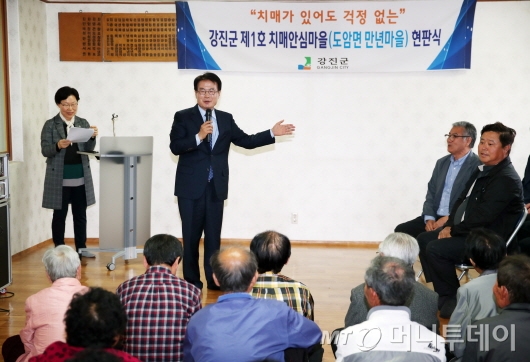 '제1호 치매안심마을' 현판식  장면.<br>
전남 강진군은 지난 23일 강진군 ‘제1호 치매안심마을’인 도암 만년마을에서 현판식을 가졌다.<br>
‘치매안심마을’은 치매 환자와 가족들의 삶의 질을 높이고 돌봄 부담을 경감시키기 위해 추진되는 사업이다. 지역 주민이 동참하는 마을자체 안전망 구축으로 치매환자와 가족, 지역주민이 상생 할 수 있는 환경 조성이 주된 목적이다.<br>
도암면 만년마을이 치매 안심마을로 선정된 이유는 마을 전체인구 67명 중 무려 49명이 60세 이상으로, 이중 10%가 치매를 앓고 있다. 또한, 마을 어르신들이 읍내 보건소 치매안심센터를 자유로이 이용할 수 없는 불편 등을 고려해 마을과 공공기관이 협업을 통해 집중적인 치매환자관리와 노인돌봄사업을 추진키 위함이다.사진제공=강진군.