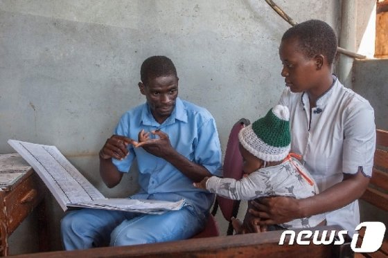 말라리아 예방접종에 대해 설명하는 의료인 &copy; AFP=뉴스1