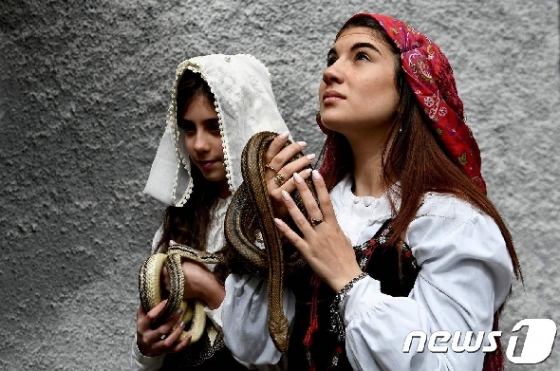 ÇÑ ¿©¼ºÀÌ ÀÌÅ»¸®¾Æ ÄíÄð·Î ¸¶À» ¹ìÃàÁ¦¿¡¼ ¹ìÀ» Àâ°í ±âµµÇϰíÀÖ´Ù. © AFP=´º½º1