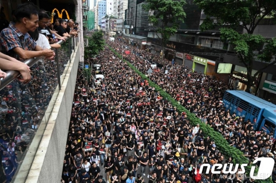 (홍콩 AFP=뉴스1) 우동명 기자 = 16일(현지시간) 범죄인 인도법 철회를 주장하는 홍콩 시민들이 검은색 옷을 입고 대규모 시위를 벌이고 있다. 이날 시위는 200만명이 참여해 이번 사태 이후 최대 규모로, 범죄인 인도법 완전 철회와 캐리 람 홍콩 행정장관의 퇴진을 요구하며 시내 곳곳에서 '검은 대행진'을 벌였다. © AFP=뉴스1 <저작권자 © 뉴스1코리아, 무단전재 및 재배포 금지>