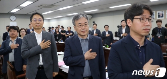 <br>
최저임금위원회 공익위원들이 11일 정부세종청사 고용노동부 전원회의장에서 열린 최저임금위원회 12차 전원회의에서 국민의례를 하고 있다. 2019.7.11/뉴스1
