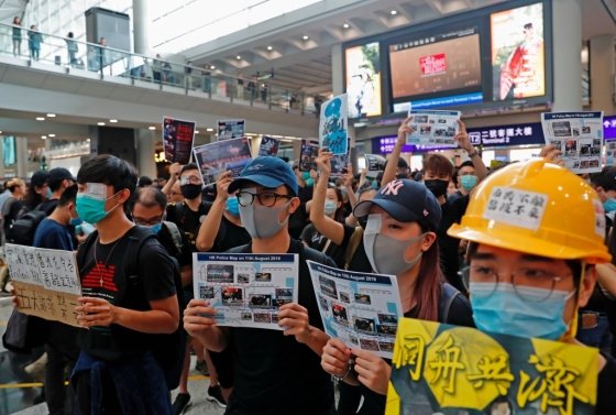 12일 홍콩 국제공항에서 진행된 반정부 시위에서 전날 경찰이 쏜 총탄에 시위 참가자가 실명한 사건에 항의하는 의미로 한쪽 눈을 가리고 참가한 시민들. /사진=로이터통신