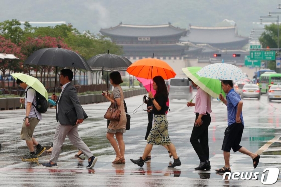 지난 12일 오전 서울 종로구 광화문네거리에서 우산을 쓴 시민들이 출근길 발걸음을 재촉하고 있다./사진=뉴스1