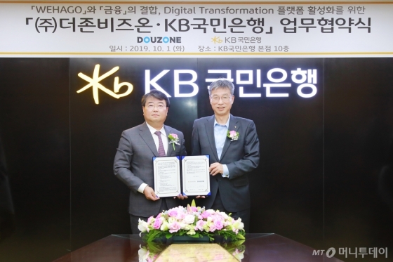 김용우 더존비즈온 대표(왼쪽)와 허인 KB국민은행장이 업무협약서를 교환하고 있다/사진제공=더존비즈온