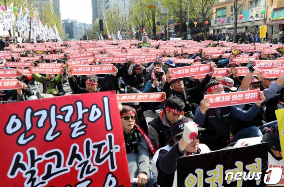 13일 오후 서울 종로구 우정국로에서 열린 특수고용노동자 총궐기대회 참가 노동자들이 '노동3권 완전 쟁취'가 적힌 손 펼침막을 들고 구호를 외치고 있다. 2019.4.13/사진=뉴스1