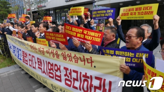 서울개인택시조합 소속 택시 기사들이 8일 서울 성동구 쏘카 서울 사무소 앞에서 기자회견을 열고 렌터카 대여 서비스 타다(TADA)의 운영사 브이씨엔씨(VCNC)를 규탄하고 있다. 2019.10.8/뉴스1