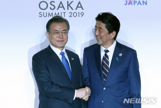문재인 대통령 지난 6월28일 일본 오사카 국제컨벤션센터 인텍스오사카에서 열린 G20 정상회의 공식환영식에서 아베 신조 일본 총리와 악수하고 있다. /뉴시스