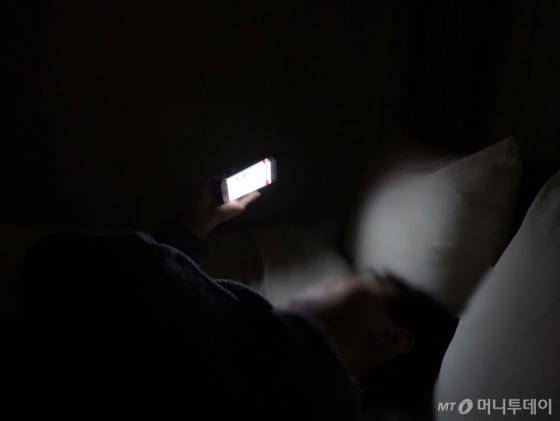 어둠 속에서 악플을 보는 남기자. 저러다 졸면 스마트폰과 얼굴이 만나게 된다. 그럼 잠이 확 깬다./사진=남형도 기자 아내