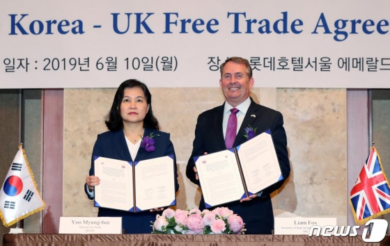 유명희 산업통상자원부 통상교섭본부장과 리암 폭스(Liam Fox)영국 국제통상부 장관이 10일 오전 서울 중구 롯데호텔에서 열린 '한-영 자유무역협정 원칙적 타결 선언식'에서 협약서에 서명 후 환하게 웃고 있다. 2019.6.10/사진=뉴스1 