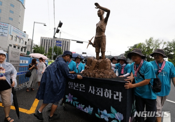 【서울=뉴시스】이영환 기자 = 광복절인 15일 오후 서울 종로구 광화문광장에서 열린 자주와 평화를 위한 8.15민족통일대회·평화손잡기 행사를 마친 참가자들이 강제징용노동자상과 함께 일본대사관 방향으로 행진하고 있다. 2019.08.15.   20hwan@newsis.com