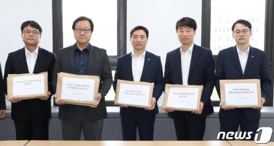5월 9일 경기도 정부과천청사에서 이상헌 SKT 정책개발실 상무(왼쪽 두번째) 등 관계자들이 SK브로드밴드와 티브로드 및 티브로드 계열법인의 M&A 관련 변경허가?인가 등 신청서를 들어보이고 있다. /사진=뉴스1.