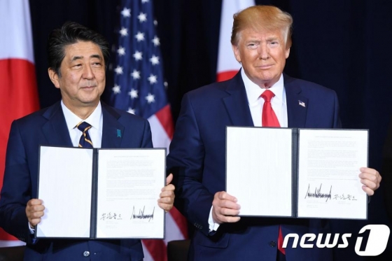 (뉴욕 AFP=뉴스1) 우동명 기자 = 도널드 트럼프 미국 대통령이 지난 9월 25일(현지시간) 뉴욕 유엔본부에서 열린 유엔총회 중 아베 신조 일본 총리와 서명한 무역협정을 들어보이고 있다. © AFP=뉴스1 <저작권자 © 뉴스1코리아, 무단전재 및 재배포 금지>