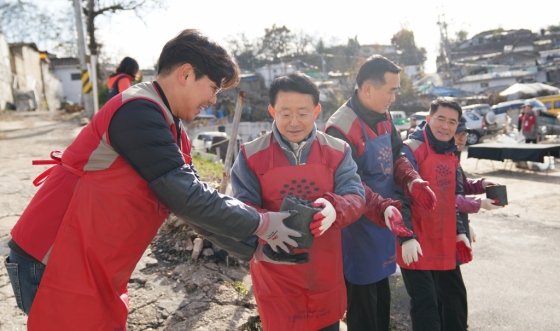 하석주 롯데건설 대표이사(왼쪽에서 두 번째)가 샤롯데 봉사단원들과 함께 연탄을 나르고 있다. /사진제공=롯데건설