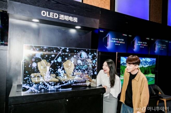 지난 9월 중국 베이징에서 열린 OLED 빅뱅 미디어 데이 행사에서 참석자들이 LG디스플레이의 55인치 투명 OLED 디스플레이를 관람하고 있다/사진제공= LG디스플레이