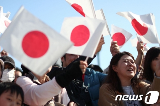 지난달 10일 일본 국기를 흔들며 일왕 행차를 환영하고 있는 일본 시민들. © AFP=뉴스1