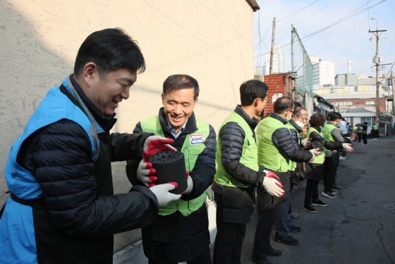 예금보험공사(이하 예보)와 서울지방보훈청이 16일 서울 동대문구 제기동에 거주하는 국가유공자를 위해 '사랑의 연탄' 나눔 행사를 실시했다. 위성백 예보 사장(왼쪽에서 두 번째)과 오진영 서울지방보훈청장(왼쪽에서 첫 번째) 등 봉사활동 참가자들이 연탄을 나르고 있다./사진제공=예보