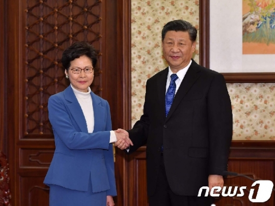 시진핑 중국 국가주석과 캐리 람 홍콩 행정장관이 16일 베이징에서 만나 악수를 나누고 있다. © AFP=뉴스1