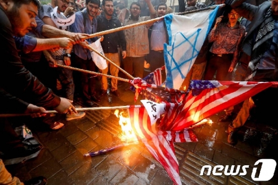 이란 테헤란의 전 미국 대사관 밖에서 불타는 성조기와 이스라엘 국기. © AFP=뉴스1