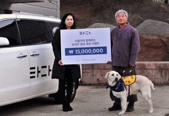 지난 9일 경기 평택 한국장애인도우미견협회에서 한서진 타다 마케팅본부장(왼쪽)과 이형구 한국장애인도우미견협회장이 훈련 중인 시각장애인도우미견과 함께 기부금 전달식 기념사진을 촬영하고 있다. /사진제공=쏘카.
