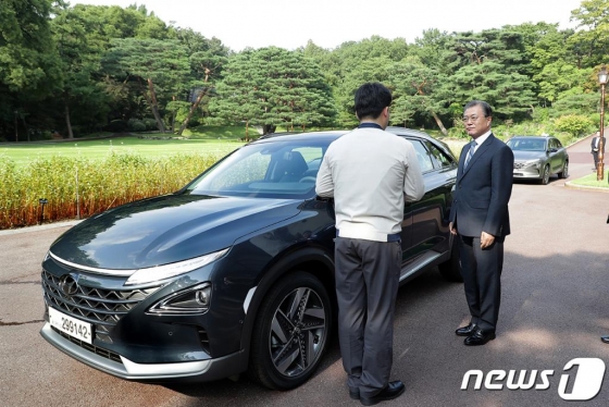 문재인 대통령이 27일 오후 청와대 녹지원 앞에서 박계일 현대차 공정기술과장으로부터 대통령 전용차로 도입된 수소차 넥쏘에 대한 설명을 듣고 있다.(청와대 제공)2019.8.27/사진=뉴스1  