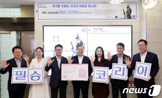 문재인 대통령이 26일 오전 중구 NH농협은행 본점에서 경쟁력 강화가 시급한 소재·부품·장비 분야 국내 기업에 투자하는 주식형 펀드인 '필승코리아 펀드'(NH-Amundi 필승코리아증권투자신탁 상품)에 가입한 후 관계자들과 기념촬영을 하고 있다. NH-아문디자산운용에서 지난 14일 출시했으며, 운용보수와 판매보수를 낮춰 그 수익이 기업에 돌아갈 수 있도록 설계됐다. 운용사측에서도 운용보수의 50%를 기초과학 분야 발전을 위한 장학금 등 공익기금으로 적립해 지원한다. (청와대 제공) 2019.8.26/뉴스1 <저작권자 © 뉴스1코리아, 무단전재 및 재배포 금지>
