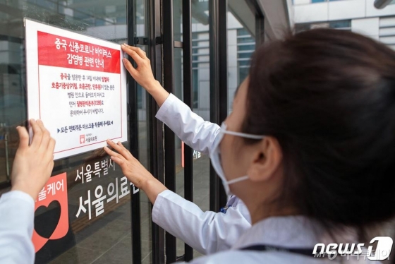 (서울=뉴스1) = 서울의료원 의료진이 감염 예방 강화를 위해 의료원 내외부에 '우한폐렴(신종 코로나바이러스)' 관련 안내문을 부착하고 있다. 서울의료원은 신종 코로나바이러스에 대응해 원내 면회객 관리를 메르스 수준으로 강화, 면회객 전원에게 마스크를 지급해 의무 착용토록 하고 열감지 장치 등으로 방문관리 강화 및 의심환자 내원대비 선별진료소를 운영한다. (서울의료원 제공) 2020.1.24/뉴스1 <저작권자 © 뉴스1코리아, 무단전재 및 재배포 금지>