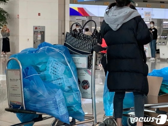 우한폐렴(신종 코로나바이러스 감염증) 확진자가 아시아를 넘어 유럽, 미주 등 전 세계로 확산되고 있는 28일 오후 인천국제공항 출국장에서 중국여행자들이 한국에서 구입한 마스크를 비닐봉투에 가득담아 출국수속을 기다리고 있다. (독자제공) 2020.1.28/뉴스1