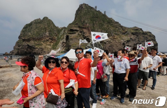 경상북도 울릉군 독도를 찾은 관광객들이 태극기를 흔들며 배에 오르고 있다. /사진=뉴스1