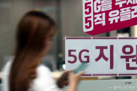5G 서비스 개통 100일이 되어가는 가운데 시민들이 10일 오후 서울 시내의 이동통신사 대리점앞을 지나고 있다./사진=임성균 기자