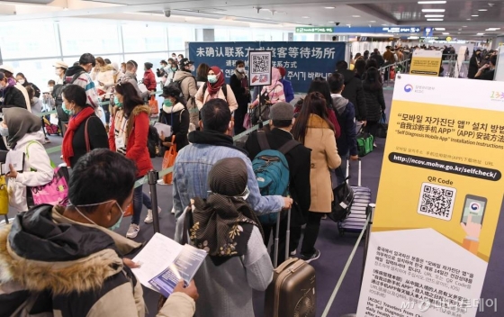 홍콩과 마카오가 코로나19 오염지역으로 지정된 13일 인천국제공항에서 홍콩발 항공편 탑승객들이 자가진단 앱을 설치를 위해 서 있다. /사진=공항사진기자단