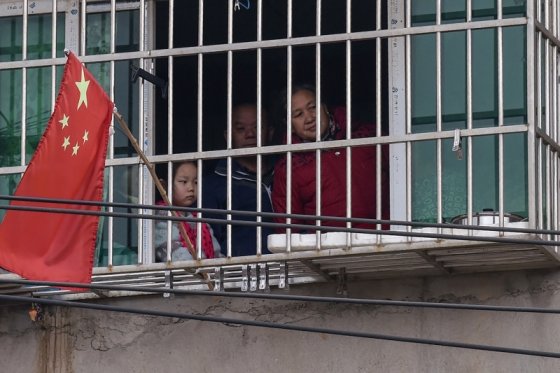 중국 우한에서 한 가족이 집 밖 창문을 내다보고 있다. /사진 = 포린 폴리시