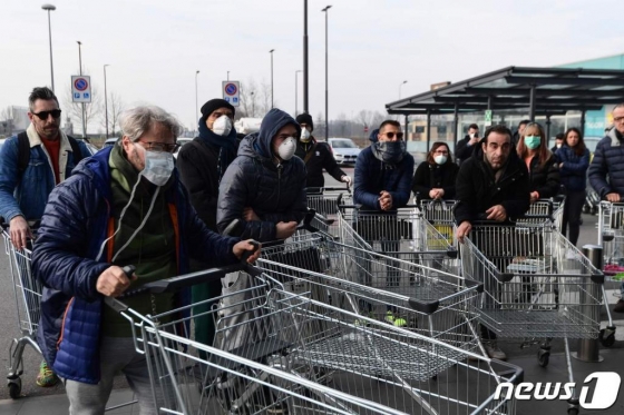 지난달 23일(현지시간) 코로나 19 감염자의 확산 속 이탈리아 카살푸스테렌고의 슈퍼마켓 앞에서 주민들이 생필품을 사기 위해 슈퍼 문이 열리기를 기다리고 있다. /AFP=뉴스1