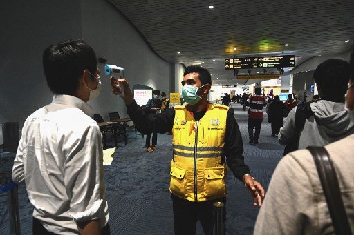 인도네시아 출입국 관련 직원이 2월 23일 인도네시아 자카르타공항에서 한 아시아인의 발열 여부를 체크하고 있다./사진=AFP 