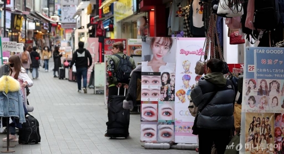 코로나19 확산이 지속되고 있는 2월 26일 오후 서울 중구 명동의 한 잡화매장 상인이 썰렁한 거리를 바라보고 있다. /사진=김창현 기자 chmt@