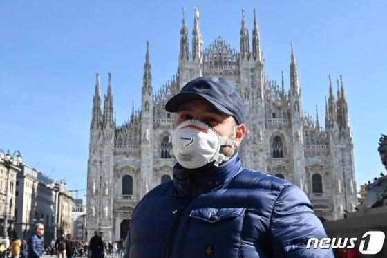 (AFP=뉴스1) 송원영 기자 =   24일 (현지시간) 이탈리아 북부 밀라노에서 신종 코로나바이러스 감염증(코로나19) 우려로 마스크를 착용한 한 시민이 두오모 대성당 앞을 지나가고 있다. 일간 라 레푸블리카&middot;ANSA 통신 등에 따르면 이날 북부 롬바르디아에서만 4명의 사망자가 발생했다. 이탈리아의 코로나19 사망자는 총 7명으로 늘었다.   &copy; AFP=뉴스1