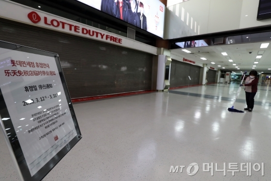 코로나19 여파로 김포공항 내 운영 중인 롯데면세점이 휴점에 돌입한 12일 김포국제공항 국제선 청사 내 롯데면세점의 셔터 문이 내려가 있다. / 사진=이기범 기자 leekb@
