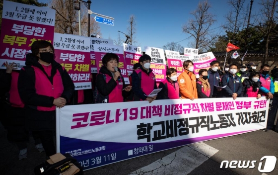 (서울=뉴스1) 유승관 기자 = 민주노총 서비스연맹 전국학교비정규직노동조합 조합원들이 11일 서울 종로구 정부서울청사 창성동별관 앞에서 기자회견을 열고 신종 코로나바이러스 감염증(코로나19) 대책 비정규직 차별 문재인 정부를 규탄하고 있다.  이들은 코로나19로 인해 전국 유치원, 초중고교의 휴업조치가 3주까지 연장돼 10만 학교비정규직노동자가 무임금 휴업을 하고 있다며 생계대책 마련을 촉구했다. 2020.3.11/뉴스1